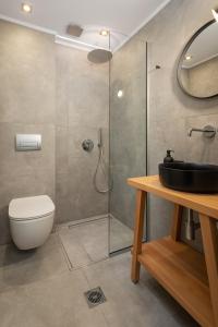 uma casa de banho com um chuveiro, um WC e um lavatório. em Hypnos Cozy Living em Ioannina