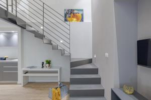 uma escada numa sala de estar com uma televisão em Suite Roma - by MyHomeInComo em Como