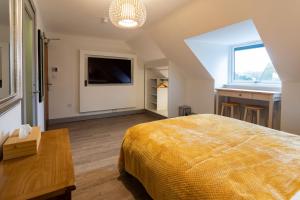 a bedroom with a bed and a television and a table at Magnolia House, Rye in Rye