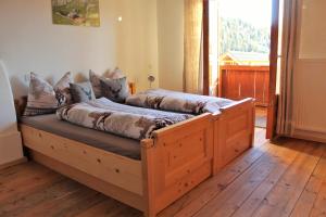2 łóżka w pokoju z drewnianą podłogą w obiekcie Lü de Terza w mieście San Vigilio di Marebbe