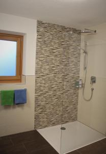 W łazience znajduje się prysznic ze szklanymi drzwiami. w obiekcie Lü de Terza w mieście San Vigilio di Marebbe