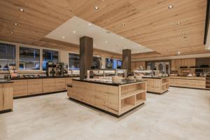 a large kitchen with wooden ceilings and wooden counters at FIRSTpeak Zauchensee in Zauchensee