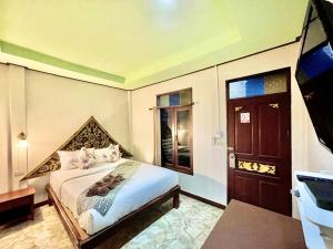 a bedroom with a large bed and a door at Khao Sok Green Valley Resort - SHA Certified in Khao Sok