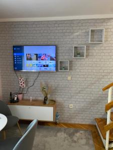 a living room with a tv on a brick wall at Apartment Cactus 021 in Novi Sad