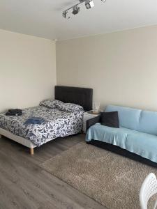 een slaapkamer met een bed en een bank bij Appartement Parc de Fresnoy in Roye