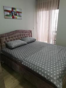 sypialnia z dużym łóżkiem z narzutą w obiekcie Apartman DalMe w mieście Novi Pazar