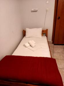 a bed with two white towels on top of it at Hotel Korydallos in Piraeus