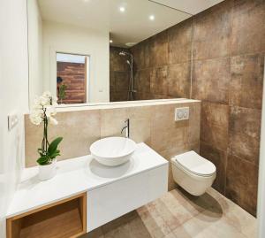 een badkamer met een wastafel, een toilet en een spiegel bij Beautiful apartment near the city center in Košice