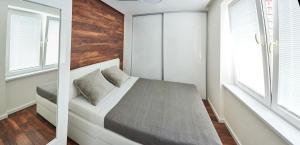 een kleine slaapkamer met een bed en 2 ramen bij Beautiful apartment near the city center in Košice