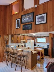 a kitchen with wooden walls and a counter with chairs at Cable Townhome #3 condo in Cable