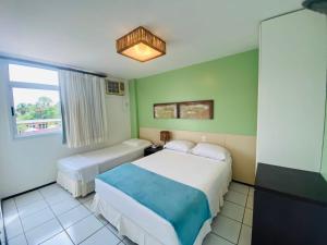 um quarto de hotel com duas camas e uma janela em Gran lençóis flat Residence em Barreirinhas
