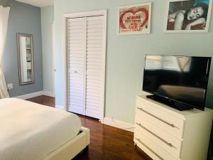 a bedroom with a bed and a television on a dresser at Sun Sand and Love - Lovely 2 Beds, 2 Bath Condo in Miami Beach