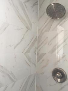 Una ducha de mármol blanco con un lavabo plateado. en Sun Sand and Love - Lovely 2 Beds, 2 Bath Condo, en Miami Beach