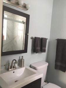 Un baño con lavabo, inodoro y espejo. en Sun Sand and Love - Lovely 2 Beds, 2 Bath Condo, en Miami Beach 11 fotos más