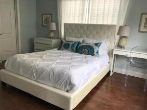 Schlafzimmer mit einem weißen Bett und einem Schreibtisch in der Unterkunft Sun Sand and Love - Lovely 2 Beds, 2 Bath Condo in Miami Beach