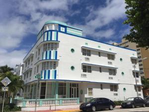 um edifício branco e azul com carros estacionados em frente em Sun Sand and Love - Lovely 2 Beds, 2 Bath Condo em Miami Beach