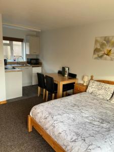 a bedroom with a bed and a kitchen with a table at Forest Edge Motel in Ticehurst