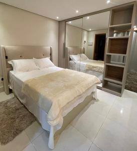 a bedroom with a large bed and a mirror at Flat encantador em Bananeiras PB in Bananeiras