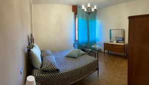 ein Schlafzimmer mit einem Bett mit einem Spiegel und einer Kommode in der Unterkunft B&B Tre Conigli sul Comò in Foligno