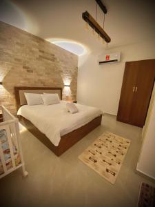 um quarto com uma cama e uma parede de tijolos em Ran suites em Mas'ada