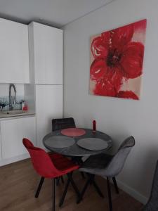 jadalnia ze stołem i 2 czerwonymi krzesłami w obiekcie Maluno Vila Apartment w Połądze