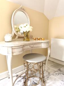 a dressing table with a mirror and a stool at Cecile's Cottage at Cefn Tilla Court, Usk in Usk