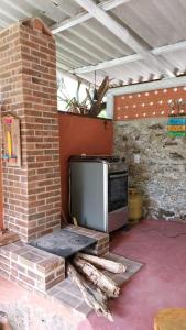 a kitchen with a stove and a brick wall at Monte Carmelo Inn Sana in Macaé