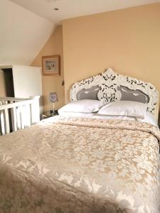 a bedroom with a large bed with white pillows at Cecile's Cottage at Cefn Tilla Court, Usk in Usk