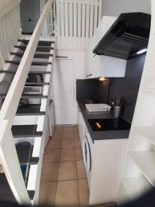 a kitchen with a sink and a staircase at Appartement villa Oceanides 500m de la plage N 8 in Soulac-sur-Mer