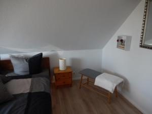 a bedroom with a bed and a table and a chair at Ferienwohnung Karen&Lemmi in Risum-Lindholm