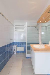 a blue and white bathroom with a sink and a shower at Sunny cottage, belle terrasse, proche et vue mer in Sainte-Luce