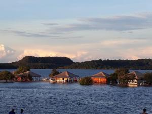 a view of a large body of water with huts at Chalé confortável em Alter do Chão in Alter do Chao