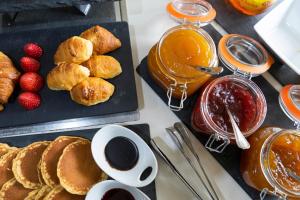 een tafel met een ontbijt van pannenkoeken en jam bij Petit Palace Vargas in Sevilla