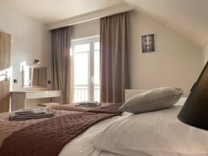 een slaapkamer met een groot bed en een raam bij MS HOUSE Apartamenty in Żywiec