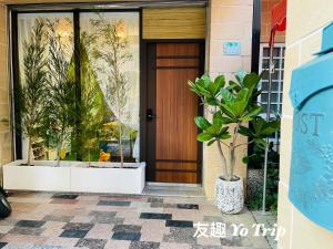 a front door of a house with potted plants at Yo Trip in Tainan