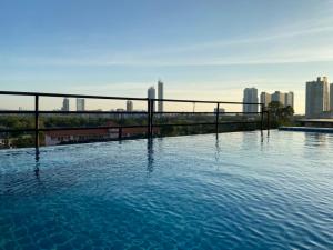 a swimming pool with a city skyline in the background at BEAR’S DEN HOTEL PATTAYA in Jomtien Beach