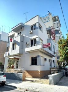 een wit gebouw met een bord ervoor bij Hotel Korydallos in Piraeus