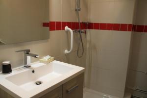 La salle de bains est pourvue d'un lavabo et d'une douche. dans l'établissement Hôtel Pontet, à Beynac-et-Cazenac