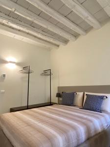 een slaapkamer met een groot bed met blauwe kussens bij Residenza SubitoSanto - Appartamento 1B "Palladio" in Padua