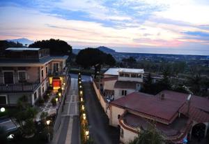 una calle de la ciudad con edificios y luces de la calle al anochecer en Hotel Le Pinede Vistamare, en Pozzuoli