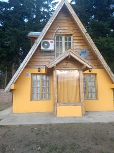 a small yellow house with a window at Cabaña El Cóndor in Epuyén