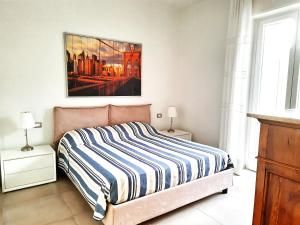 Un dormitorio con una cama y un cuadro en la pared. en Casa di Nicola, en Viareggio