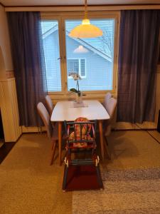 a dining room table with a chair and a window at Syväraumankatu 32 as 3 in Rauma