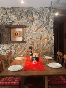 einen Holztisch mit Gläsern und eine Flasche Wein in der Unterkunft Casadolcino in Campodolcino