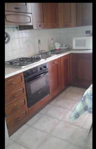 a kitchen with wooden cabinets and a stove top oven at A casa di Alice in Rome