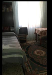 a bedroom with a bed and a tv and a window at A casa di Alice in Rome