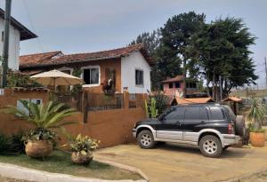 Un SUV nero parcheggiato di fronte a una casa. di Pousada Esquina de Lavras a Lavras Novas