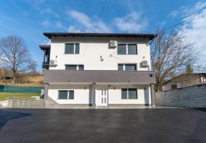 a white house with a driveway in front of it at Vila s bazenom deluxe - GTI in Zagreb