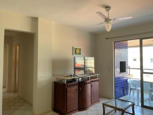 a living room with a ceiling fan and a table at APARTAMENTO 3 dormitorio VISTA PARA MAR in Bombinhas