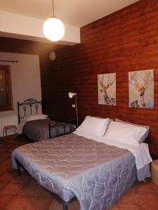 een slaapkamer met 2 bedden en een houten muur bij B&B Al Cavaliere in Lorica